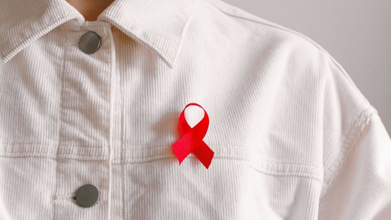 Person wearing red ribbon for AIDs awareness